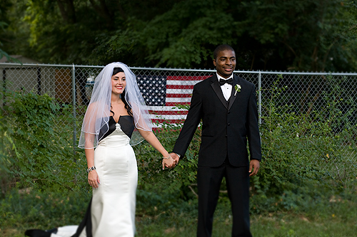 bride and groom in front of american flag