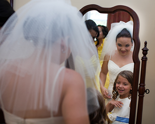 bride and flower girl looking in mirror