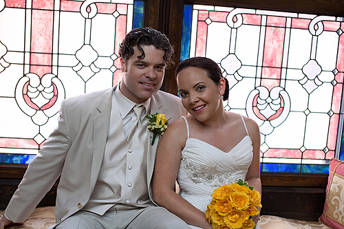 bride and groom in front of stained glass window