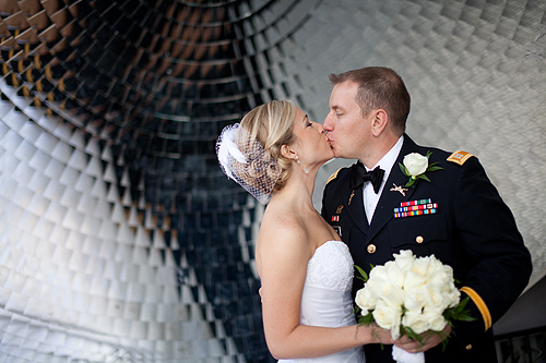 bride and groom kissing in front of the Louisville Science Center