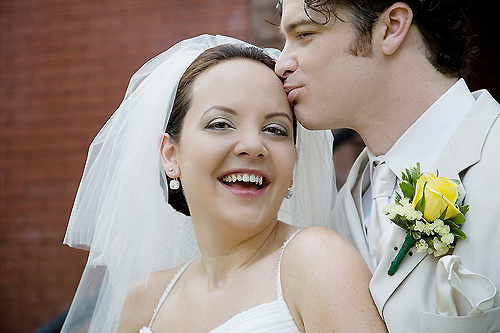 groom kissing laughing bride