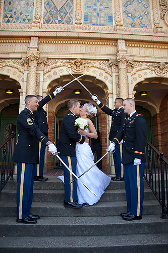 marine and bride kissing in front of historic Saint James Catholic Church in Louisville